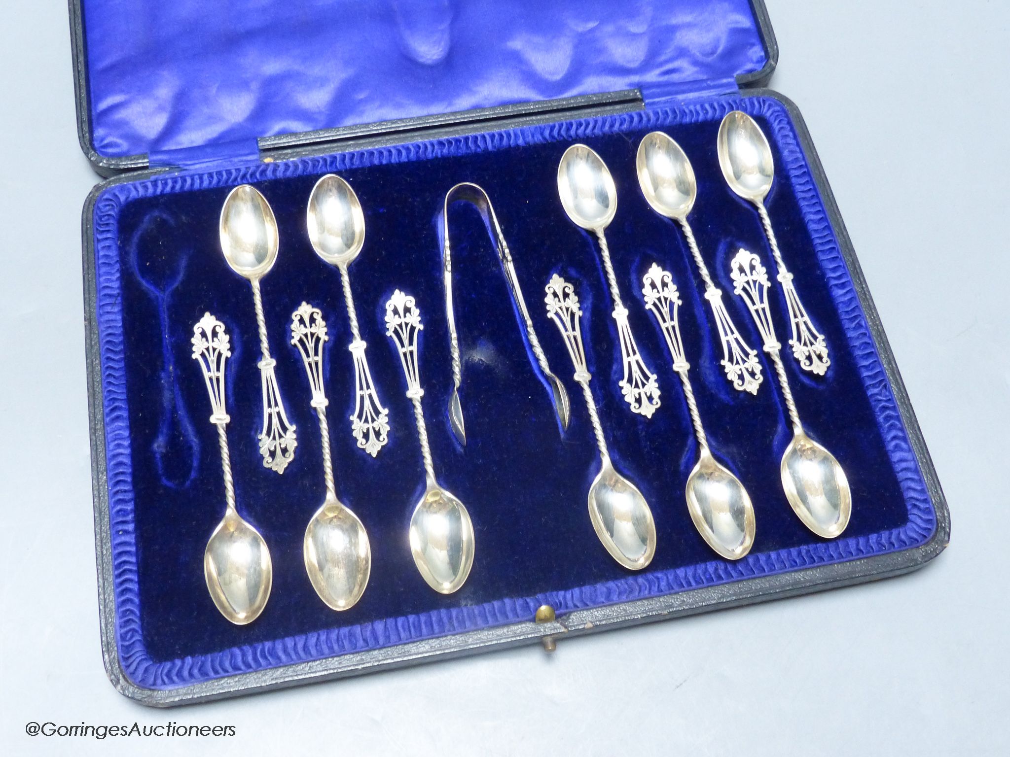 A cased set of eleven (ex 12) pierced silver teaspoons and pair of sugar tongs, John Round & Son Ltd, Sheffield, 1912